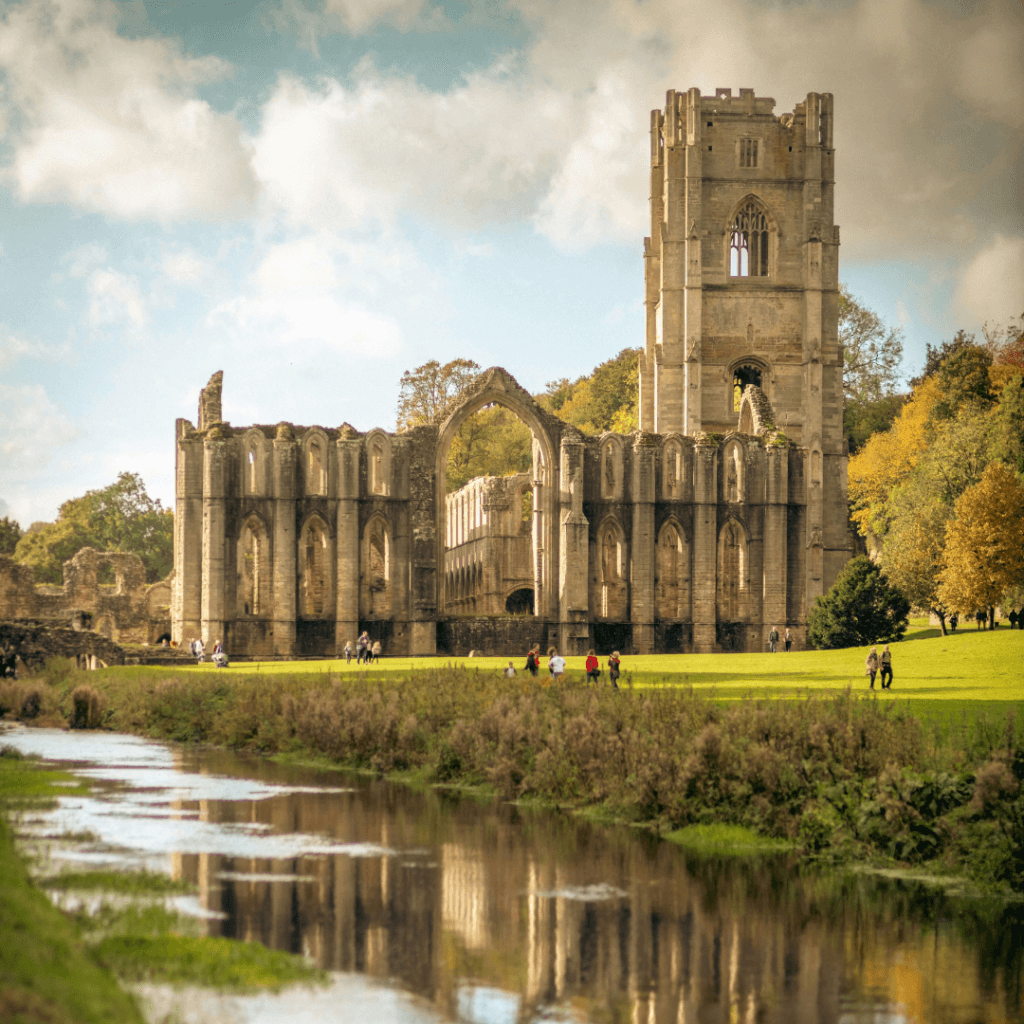 the ruins of fountains abbey beside a river